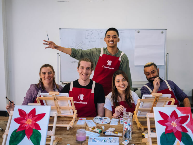 Group of people smiling at a Christmas paint and sip class